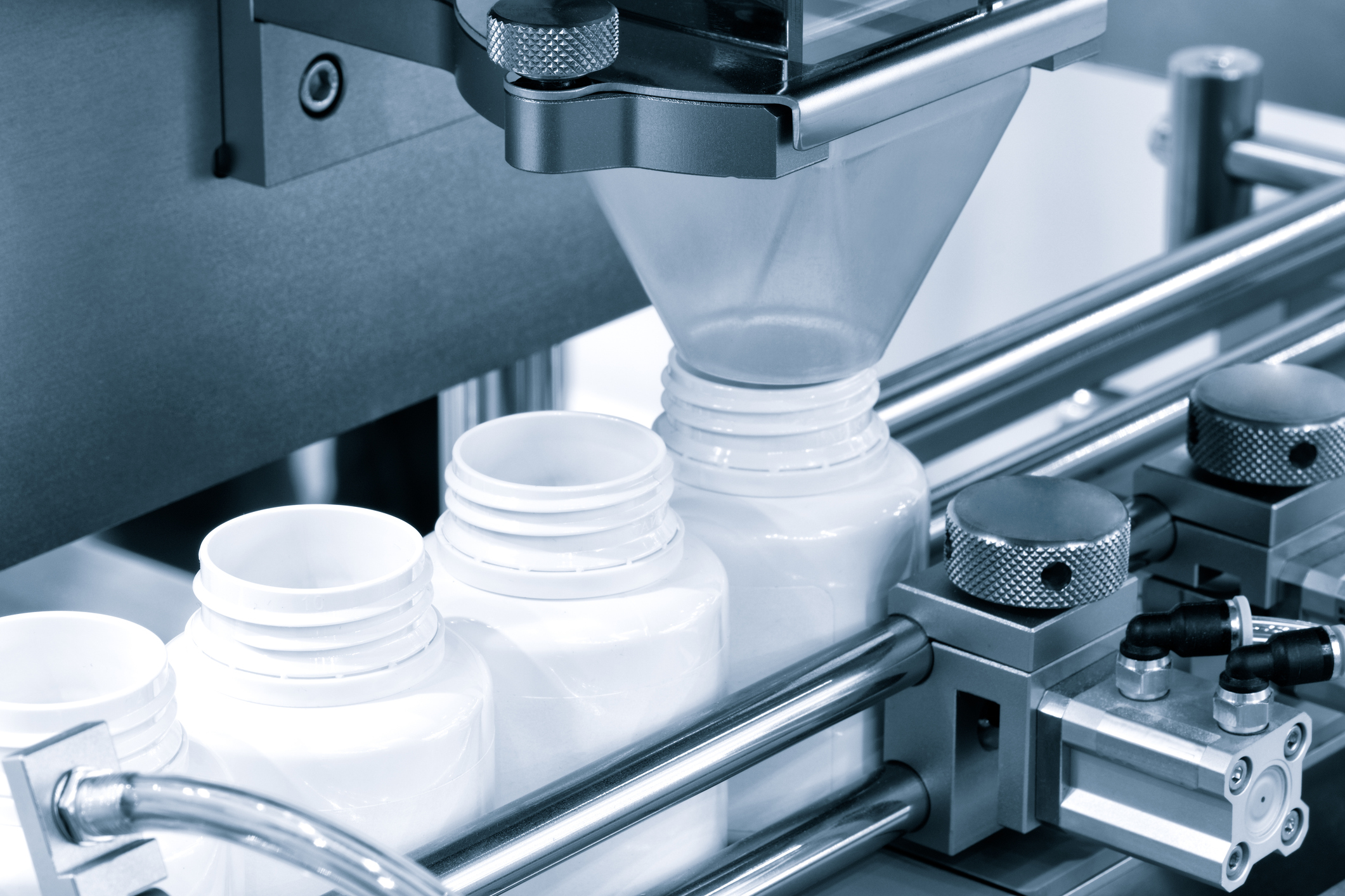 pharmaceutical industry, medicine pills are filling in the  bottle on production line machine conveyor at the medical factory. selective focus.